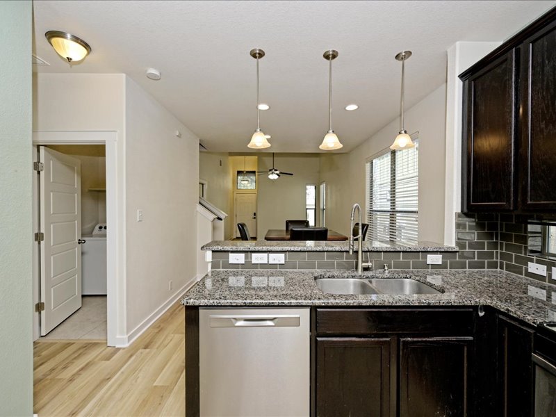 2101 Rivers Edge Way, Unit 29 Austin, TX 78741 - Photo 7 of 34 a kitchen with granite countertop a sink a counter space and stainless steel appliances