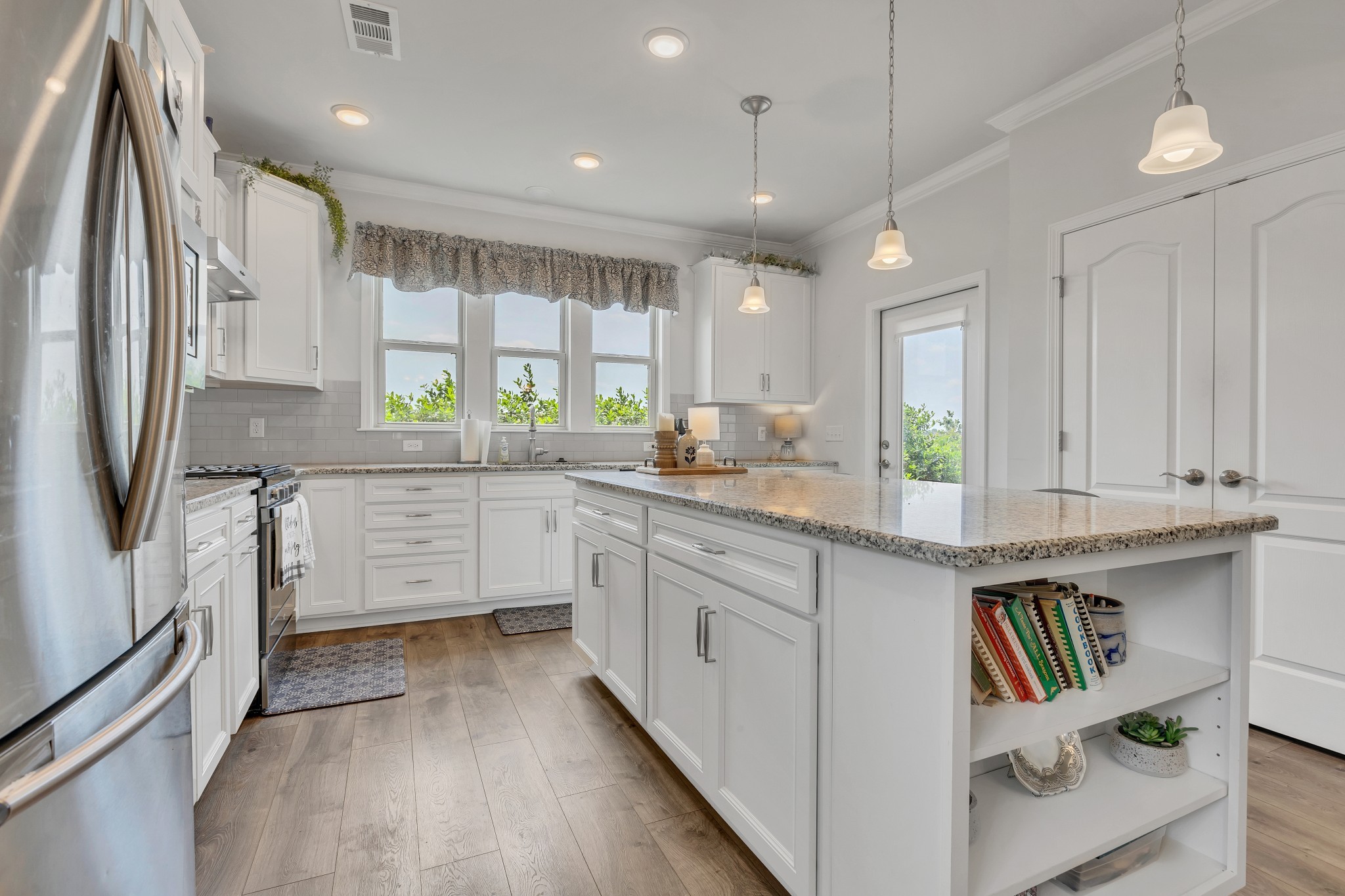 1514 Bledsoe Knoll Spring Hill, TN 37174 - Photo 15 of 47 a kitchen with stainless steel appliances granite countertop a refrigerator a sink dishwasher a stove and white countertops with wooden floor