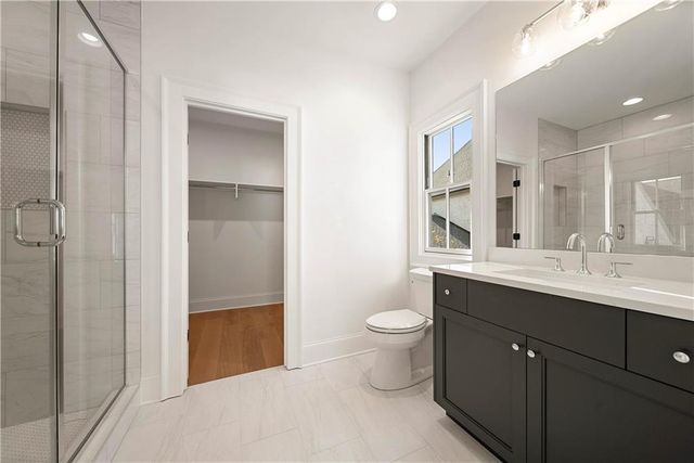 a bathroom with a double vanity sink toilet and shower