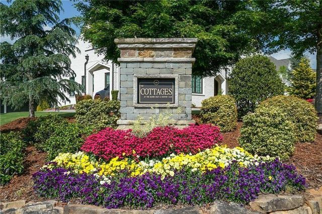 a front view of a house with a yard and fountain