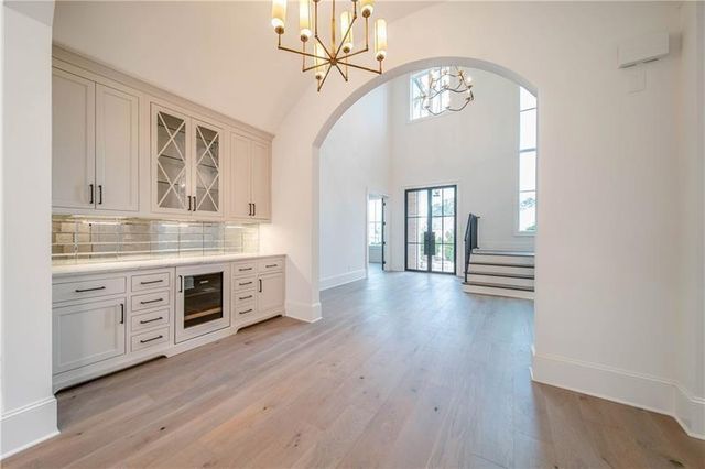 a view of a entrance and an empty room with wooden floor