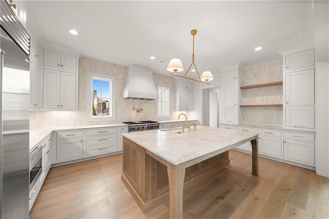 a kitchen with a stove a sink a center island and a cabinets