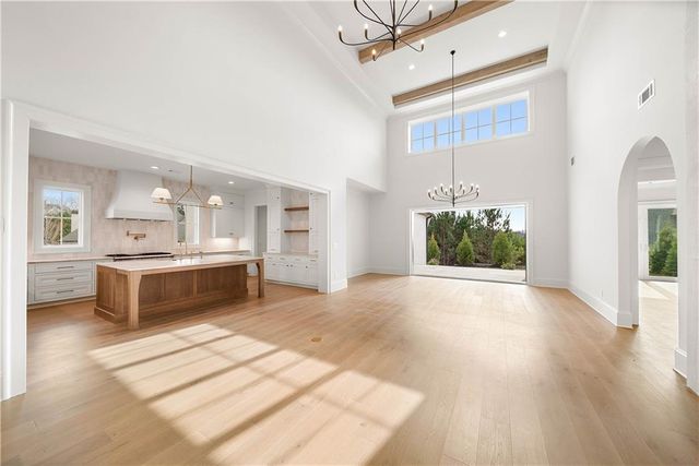 a large white kitchen with a refrigerator and a stove