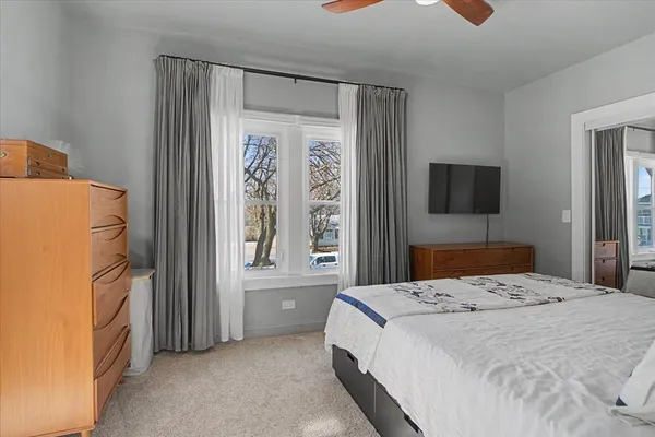 a bedroom with a bed and a flat tv screen on dresser