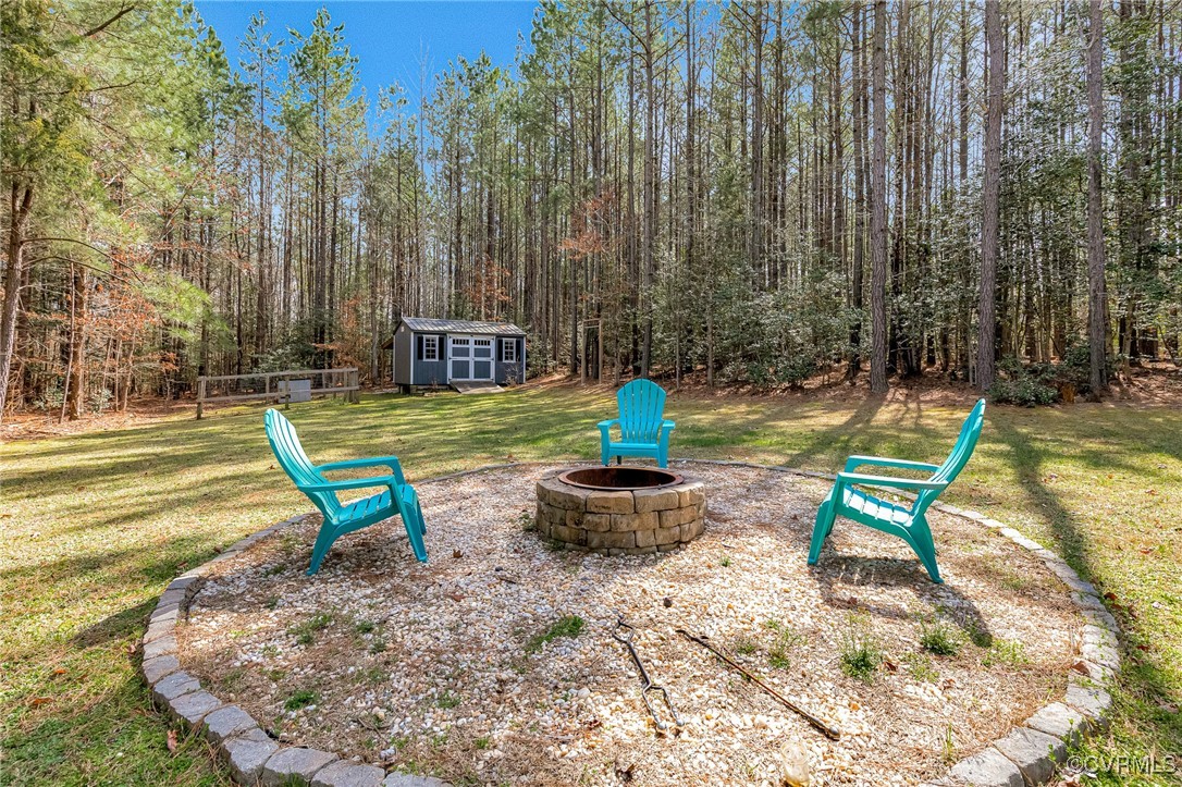 8773 Rock Cedar Road New Kent, VA 23124 - Photo 33 of 37 View of yard featuring a storage shed, a fire pit,