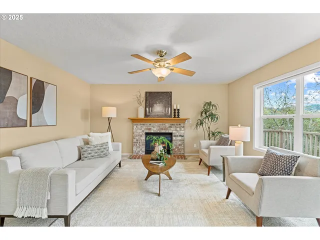 a living room with furniture a fireplace and a large window