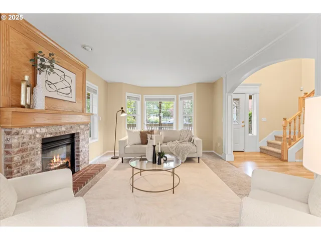 a living room with furniture a fireplace and a large mirror