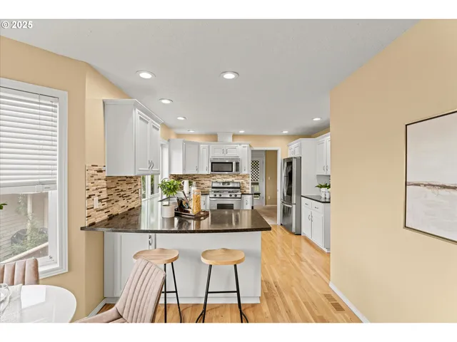 a living room with stainless steel appliances kitchen island granite countertop furniture and a large window