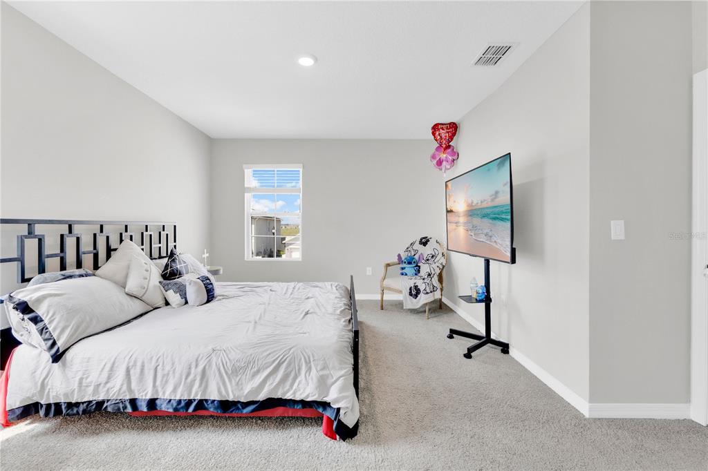 167 Eagleview Loop Davenport, FL 33837 - Photo 12 of 39 a spacious bedroom with a bed and a couch