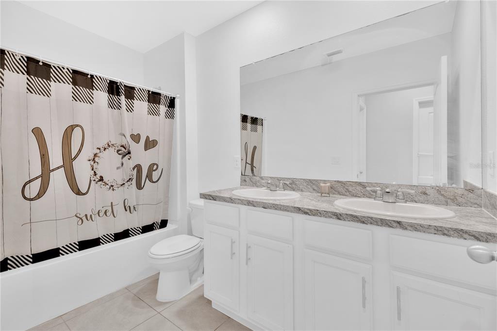 167 Eagleview Loop Davenport, FL 33837 - Photo 15 of 39 a bathroom with a granite countertop sink and a toilet