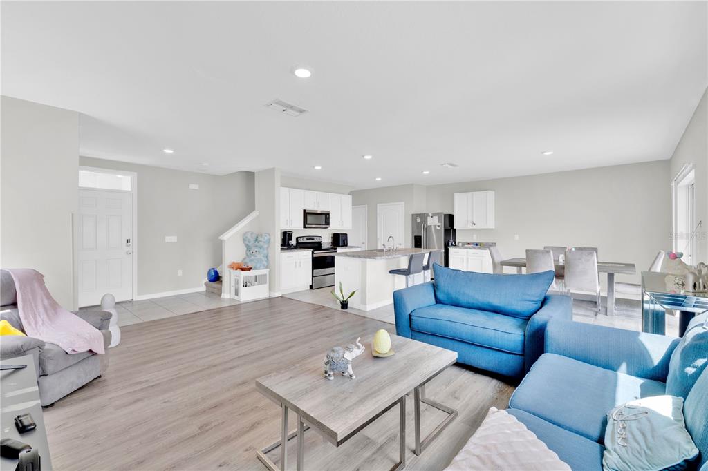 167 Eagleview Loop Davenport, FL 33837 - Photo 4 of 39 a living room with furniture kitchen view and a wooden floor