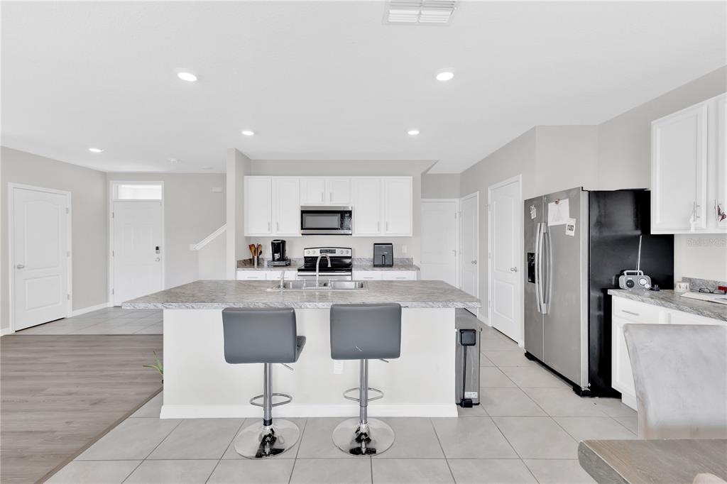 167 Eagleview Loop Davenport, FL 33837 - Photo 6 of 39 a living room with stainless steel appliances kitchen island granite countertop furniture and a refrigerator