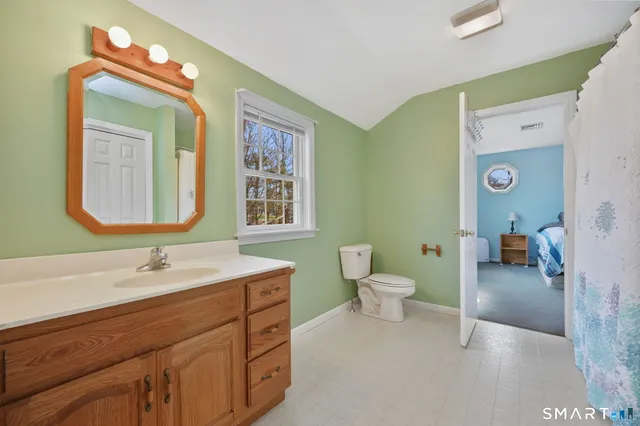 a bathroom with a toilet sink and mirror