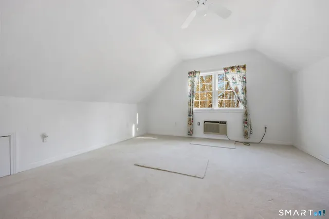 an empty room with a fireplace and windows