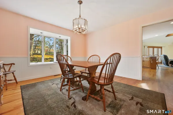 a dining room with furniture a chandelier and wooden floor