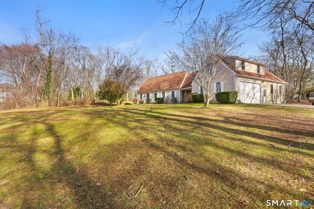 a view of an house with backyard and trees