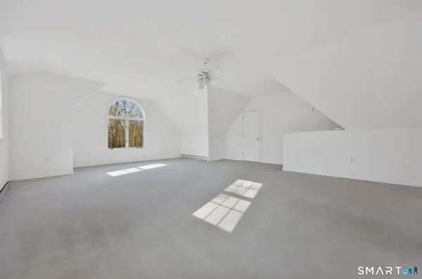 an empty room with windows and ceiling fan