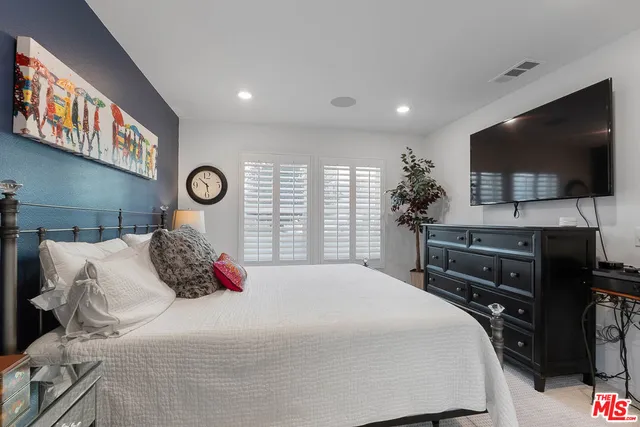 a bedroom with a large bed and a flat screen tv