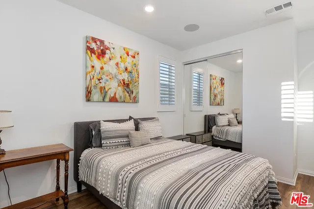 a bedroom with a bed and a painting on the wall