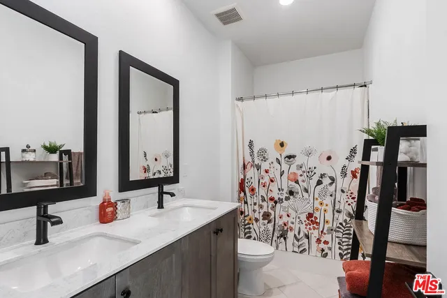 a bathroom with a double vanity sink and mirror