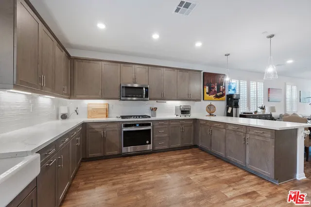 a kitchen with stainless steel appliances granite countertop a sink dishwasher stove top oven and refrigerator