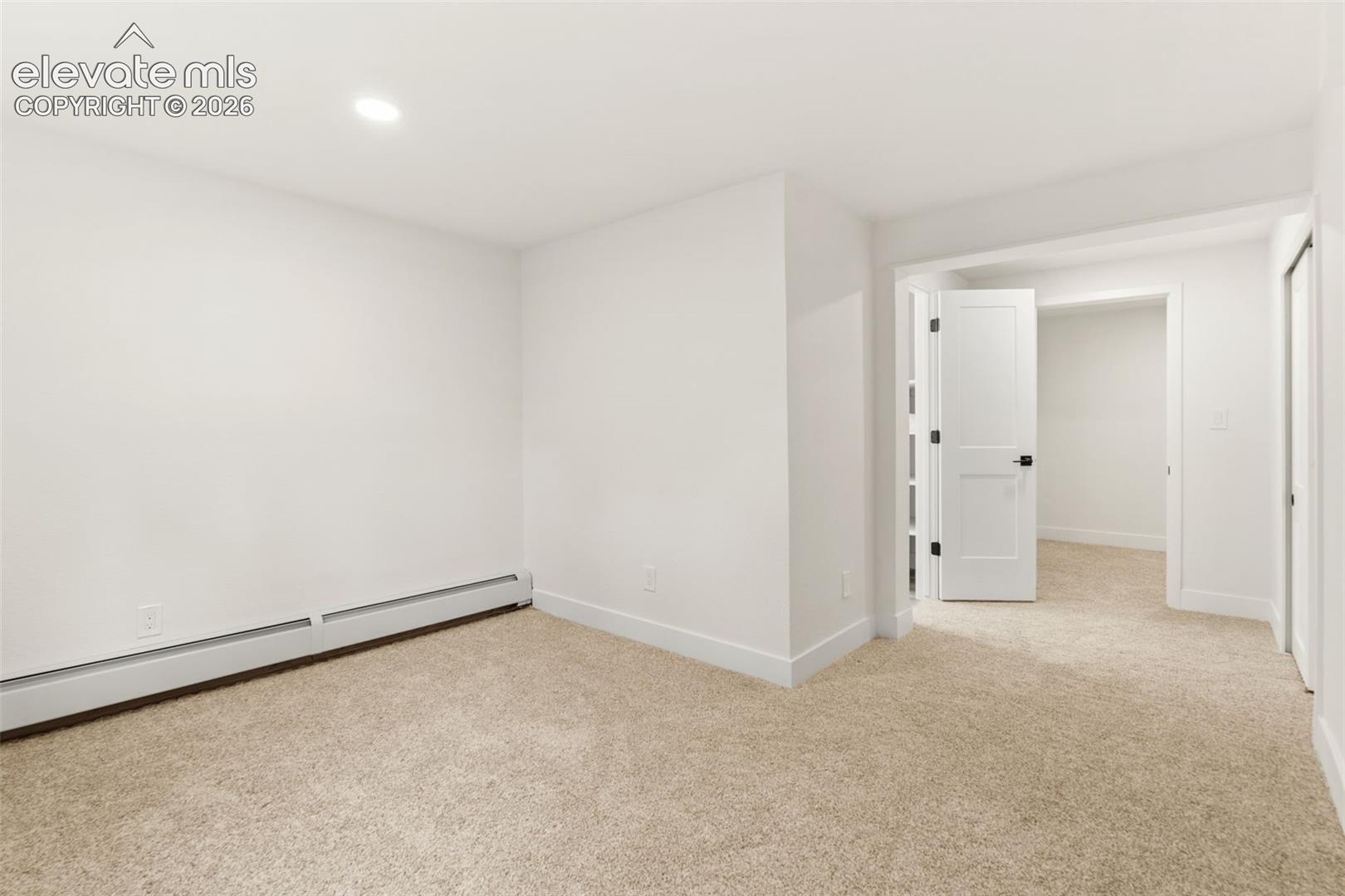 11665 Greentree Road Colorado Springs, CO 80908 - Photo 33 of 43 Unfurnished room featuring light colored carpet, recessed lighting, and a baseboard heating unit