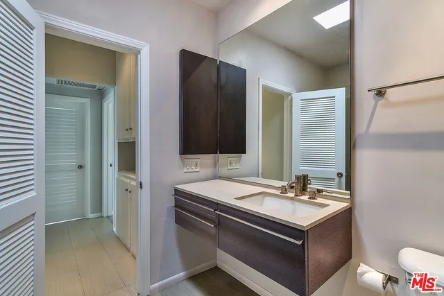 a bathroom with a sink a toilet and a mirror