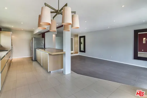a kitchen with stainless steel appliances kitchen island a refrigerator and a sink