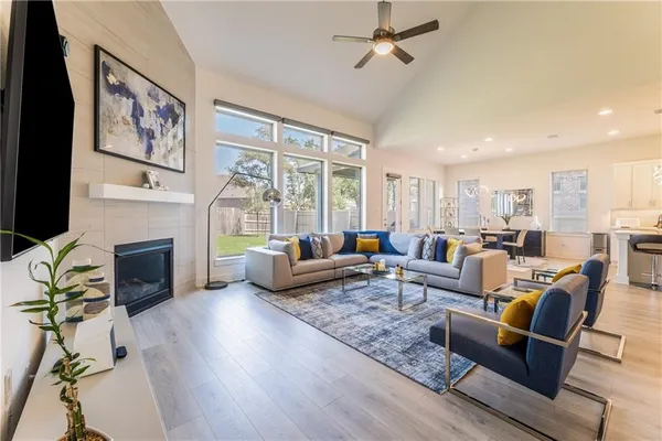a living room with furniture fireplace and a large window
