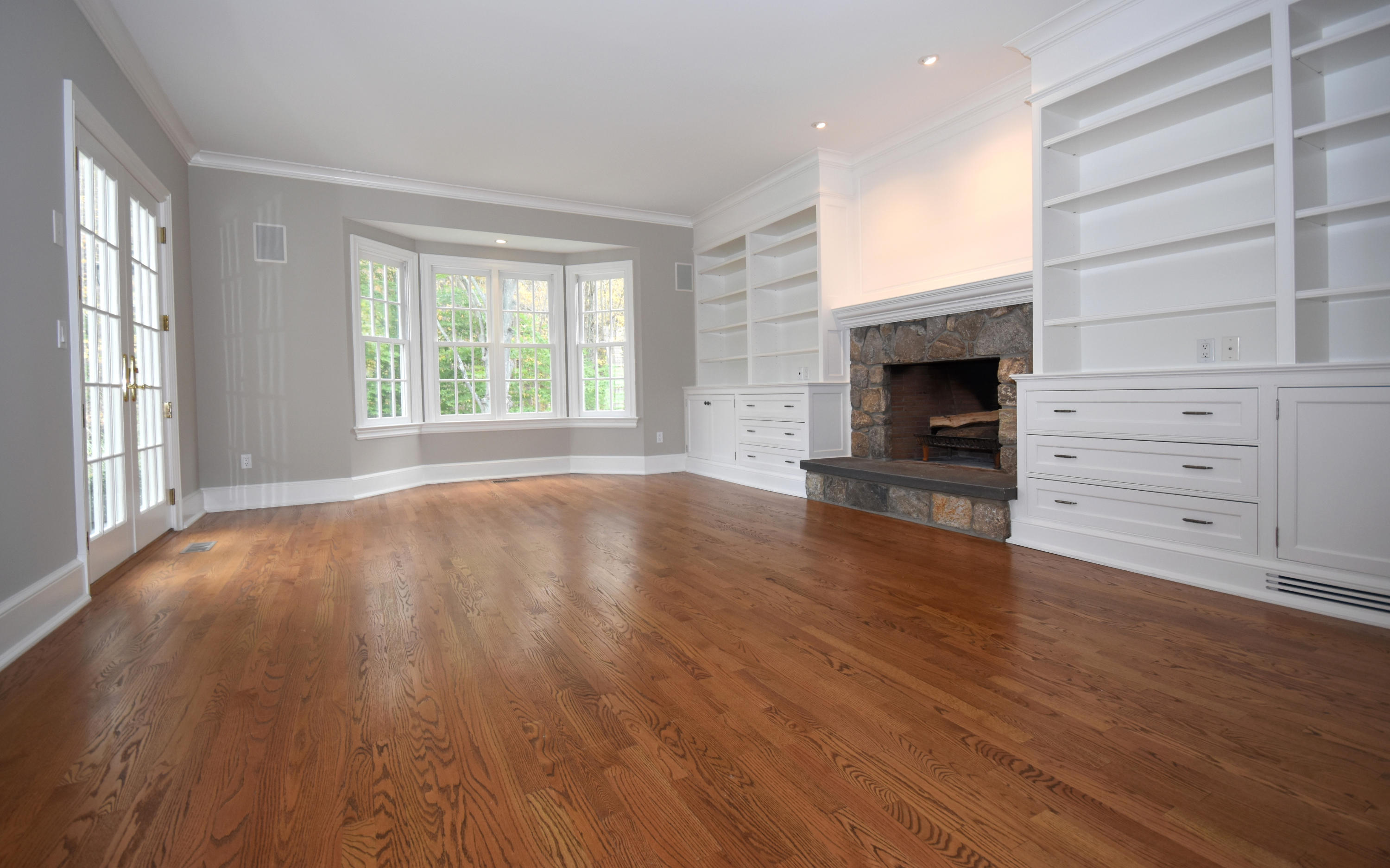 879 Valley Road New Canaan, CT 06840 - Photo 11 of 26 an empty room with wooden floor fireplace and windows