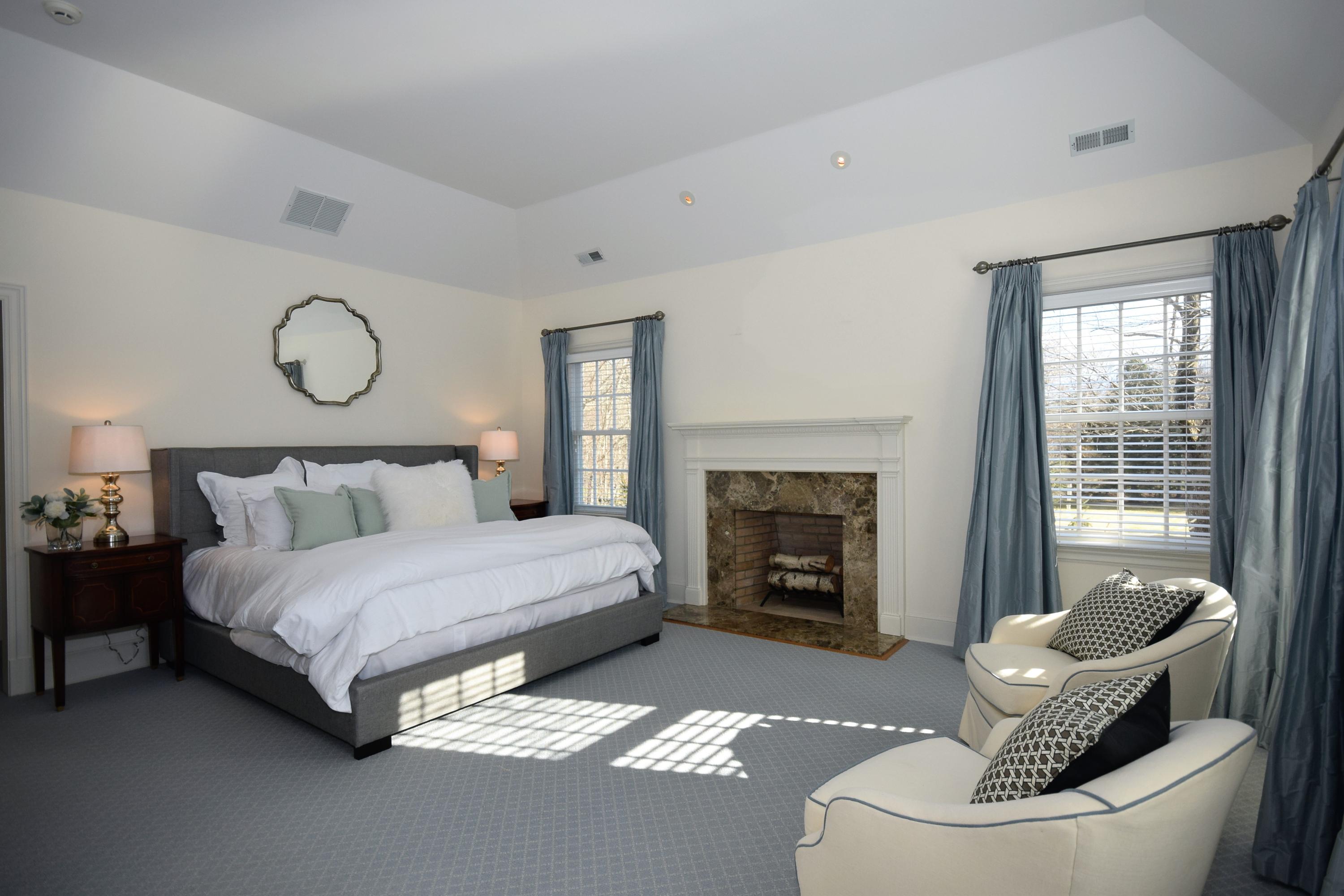 879 Valley Road New Canaan, CT 06840 - Photo 13 of 26 a spacious bedroom with a bed and a fireplace