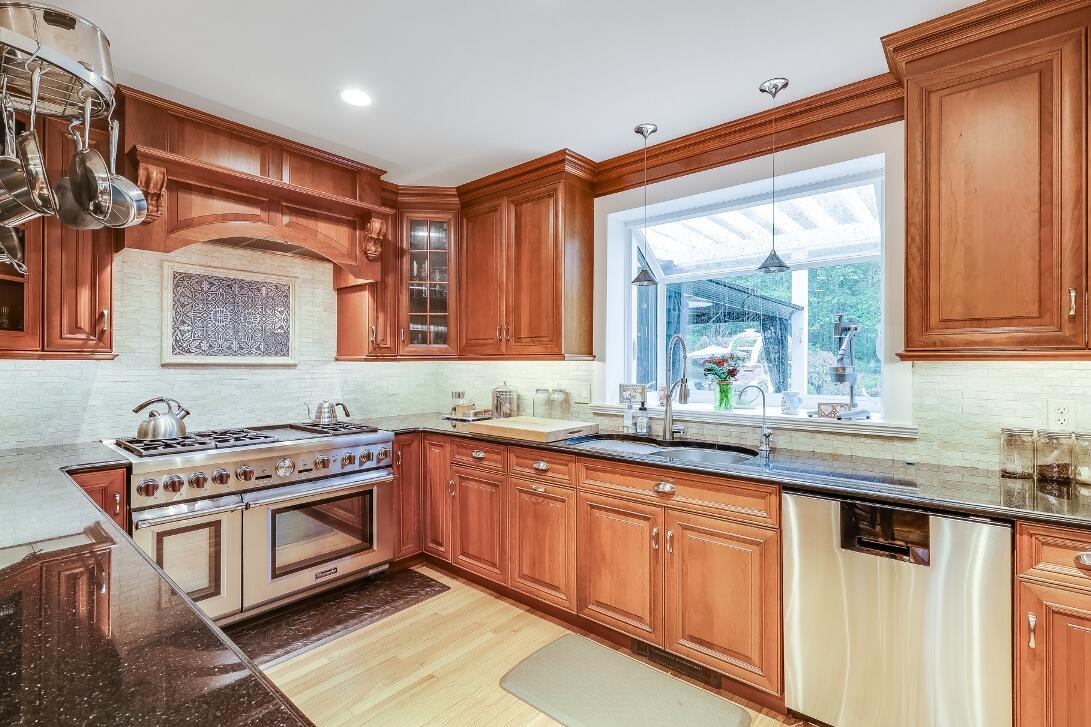 227 Run Hill Road Brewster, MA 02631 - Photo 18 of 89 a kitchen with stainless steel appliances granite countertop a sink stove and cabinets