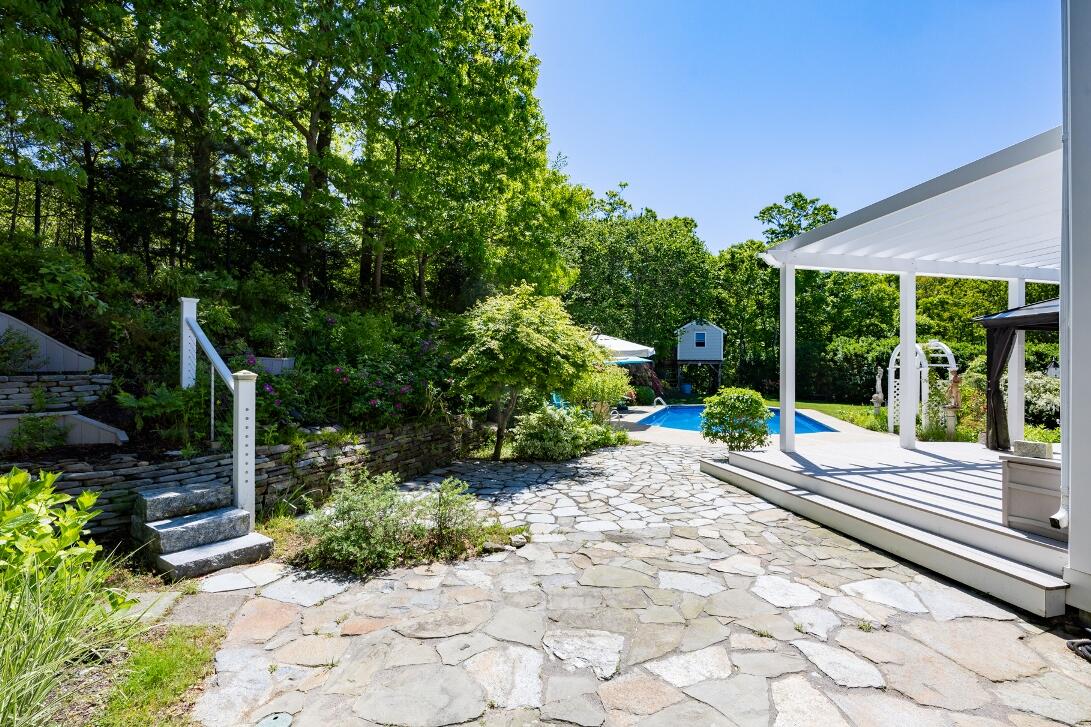 227 Run Hill Road Brewster, MA 02631 - Photo 66 of 89 a view of a back yard with flower plants and wooden fence