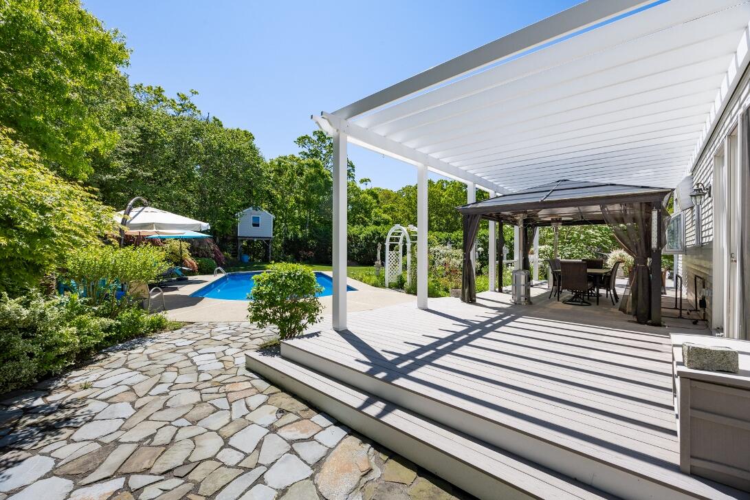 227 Run Hill Road Brewster, MA 02631 - Photo 67 of 89 a view of a patio with table and chairs potted plants and floor to ceiling window