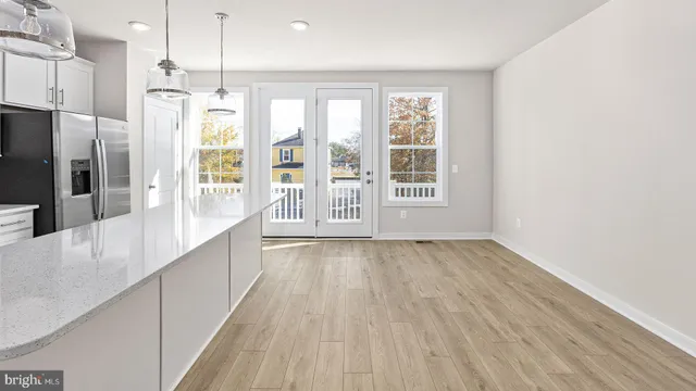an empty room with wooden floor and outdoor view