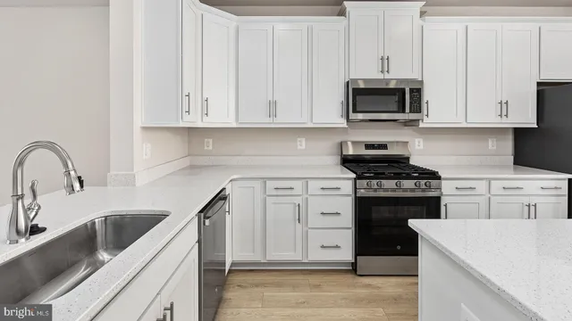 a kitchen with white cabinets and appliances