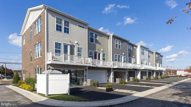 a front view of a building with street view and trees