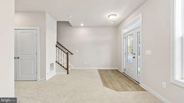 a view of hallway with stairs and a window
