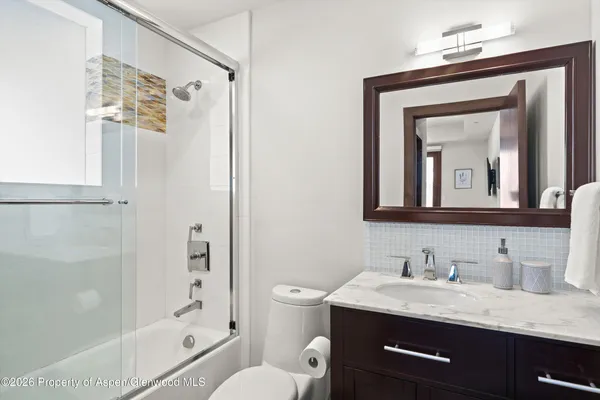a bathroom with a granite countertop sink toilet and shower
