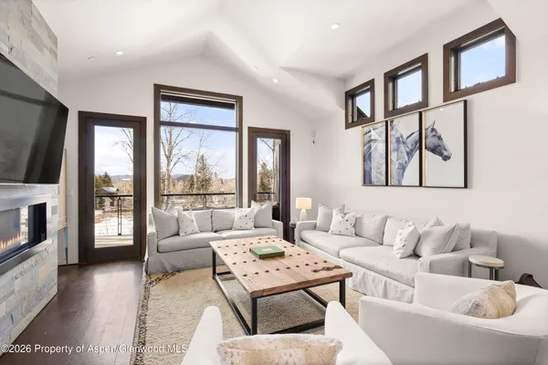 a living room with furniture large window and flat screen tv