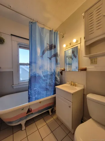 a bathroom with a sink a toilet a mirror and shower