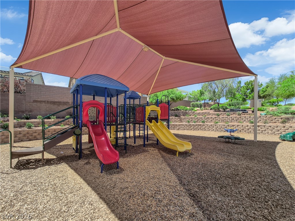646 Monument Point Street Henderson, NV 89002 - Photo 36 of 44 A community playground features colorful equipment beneath a protective shade canopy.