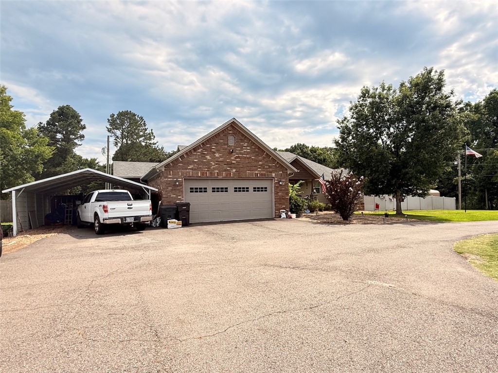 1224 River Road Pottsville, AR 72858 - Photo 33 of 37 Brick exterior home with an attached two-car garage, a separate carport structure, and an expansive paved driveway