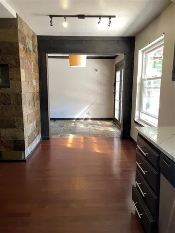 a view of empty room with window and wooden floor