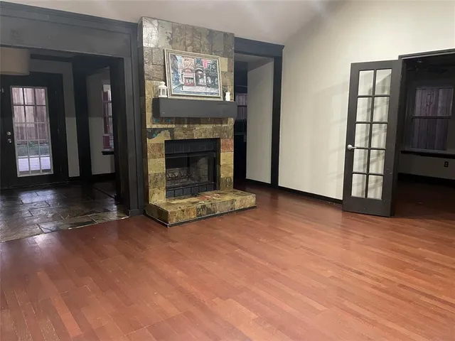 a view of a livingroom with wooden floor a fireplace and window