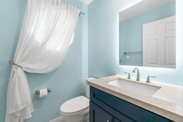 a bathroom with a sink a toilet and mirror