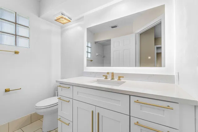 a bathroom with a toilet a sink and mirror