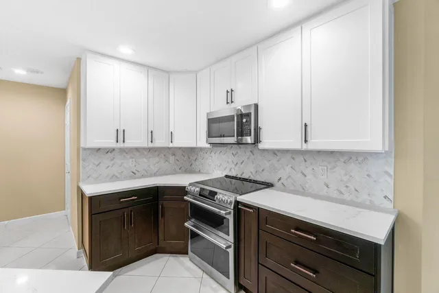 a kitchen with granite countertop cabinets stainless steel appliances and a counter space