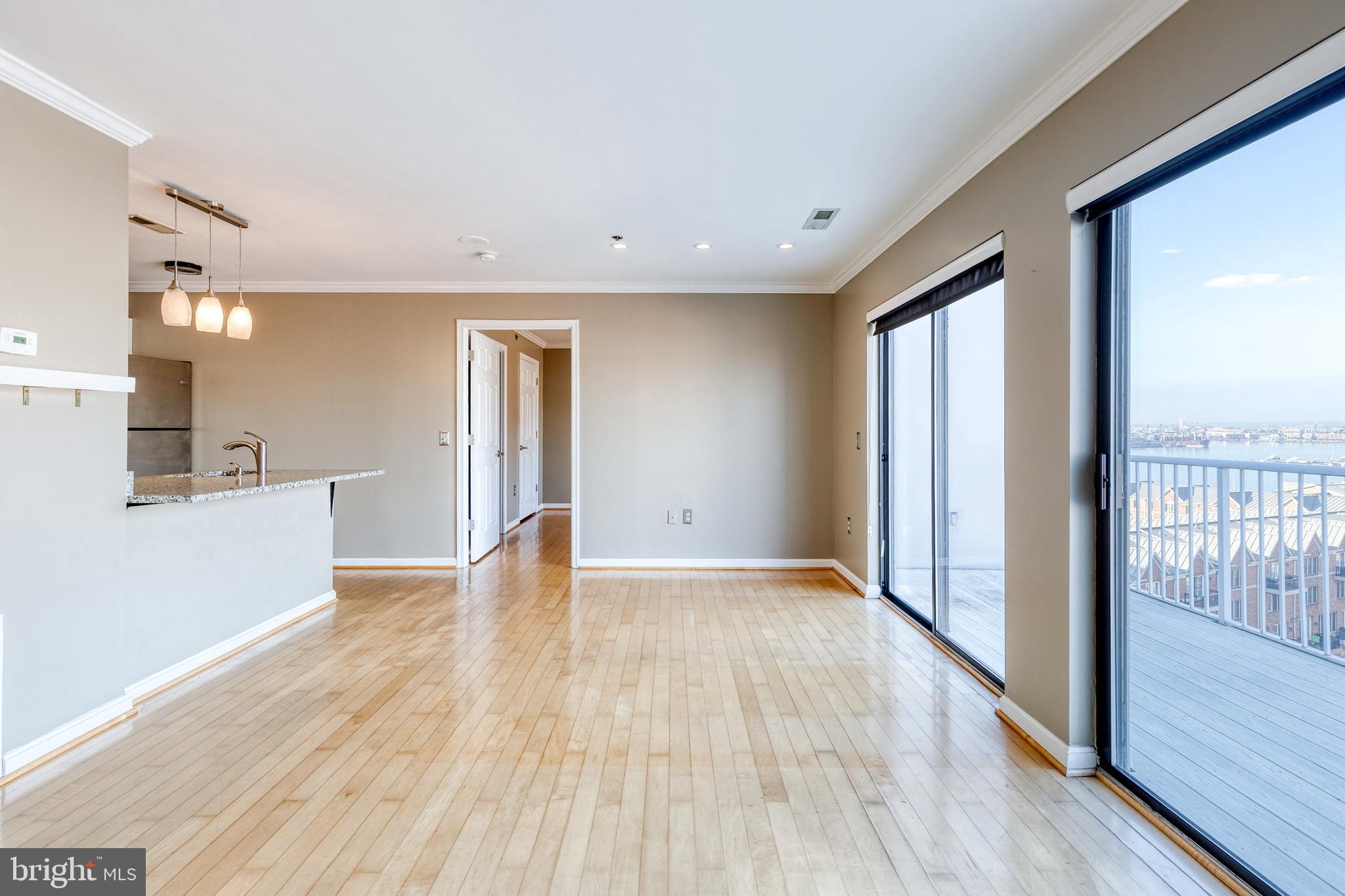 2702 Lighthouse Point East, Unit 712 Baltimore, MD 21224 - Photo 3 of 21 a view of a big room with wooden floor and windows