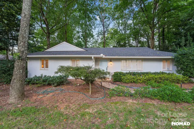 a view of a house with a yard and sitting area